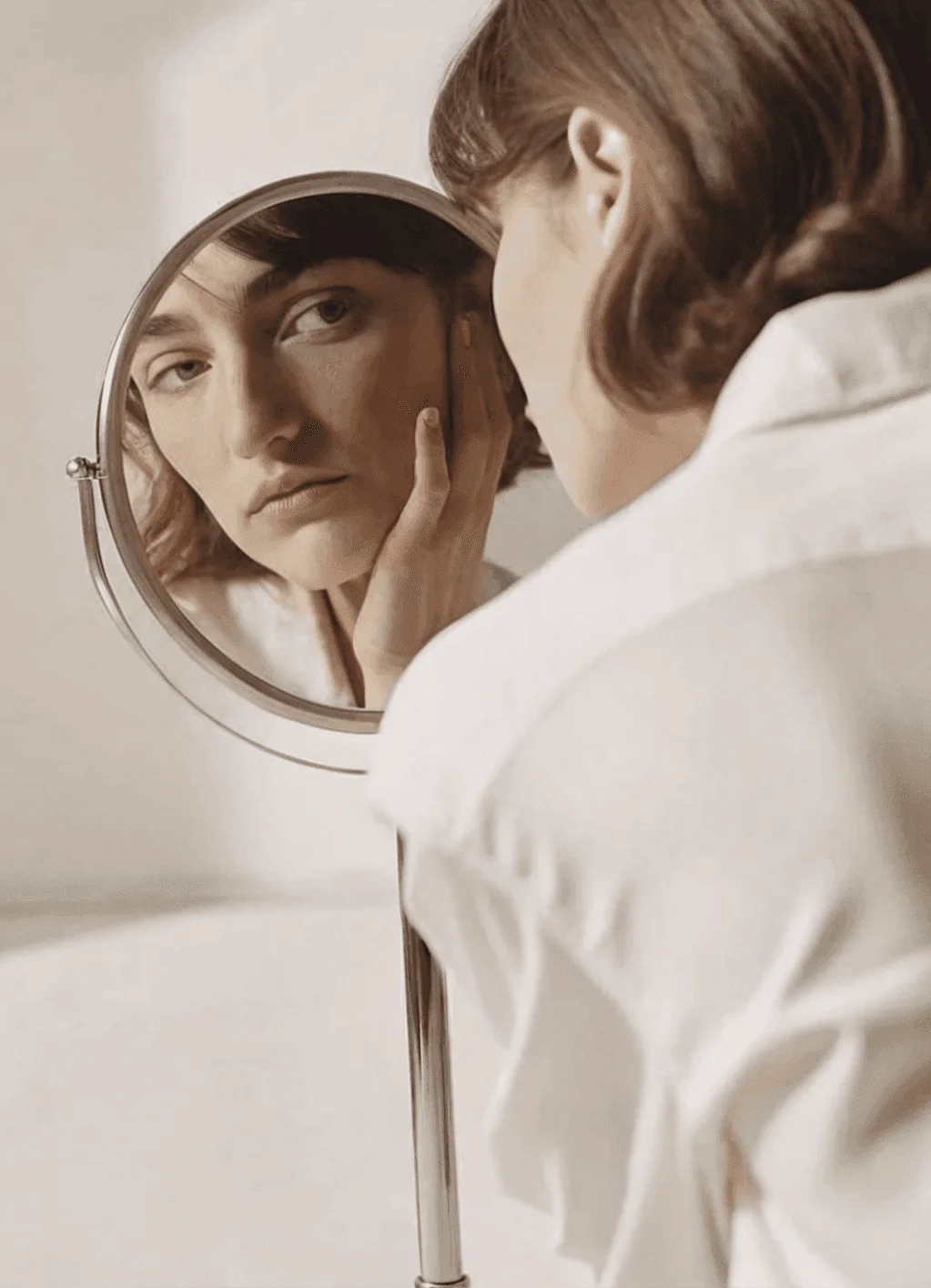 Client checking her skin in a hand mirror